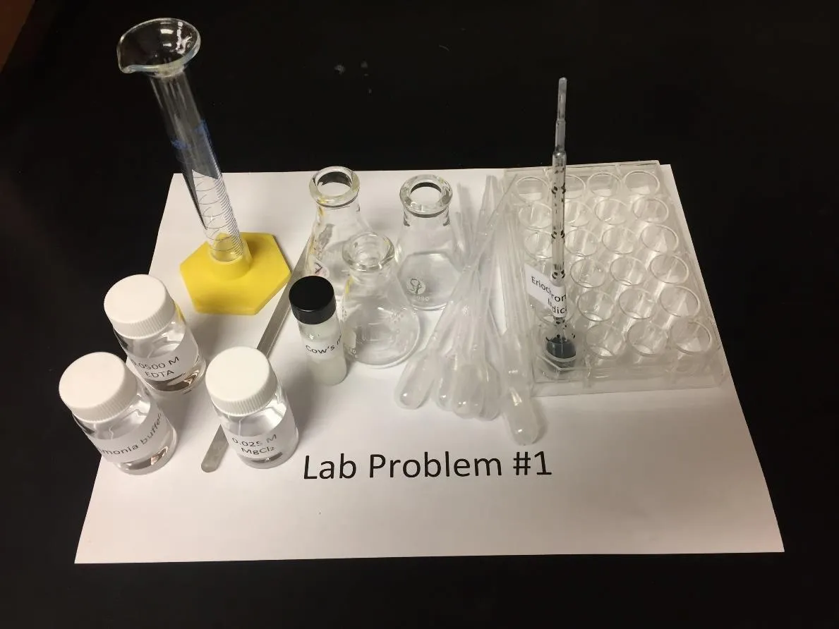 2018 USNCO Part III Problem 1 setup: EDTA solution, ammonia buffer, MgCl₂, cow's milk, Eriochrome Black T indicator, graduated cylinder, Erlenmeyer flasks, well plate